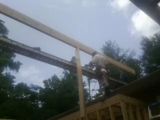 Carpenter setting a ridge beam over a new addition frame — Ice Dam Removal by Roofing Brothers in Hagerman