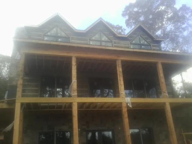 Dormers and porch framing on a large log home under construction — Roof Coating work by our crew in Hagerman