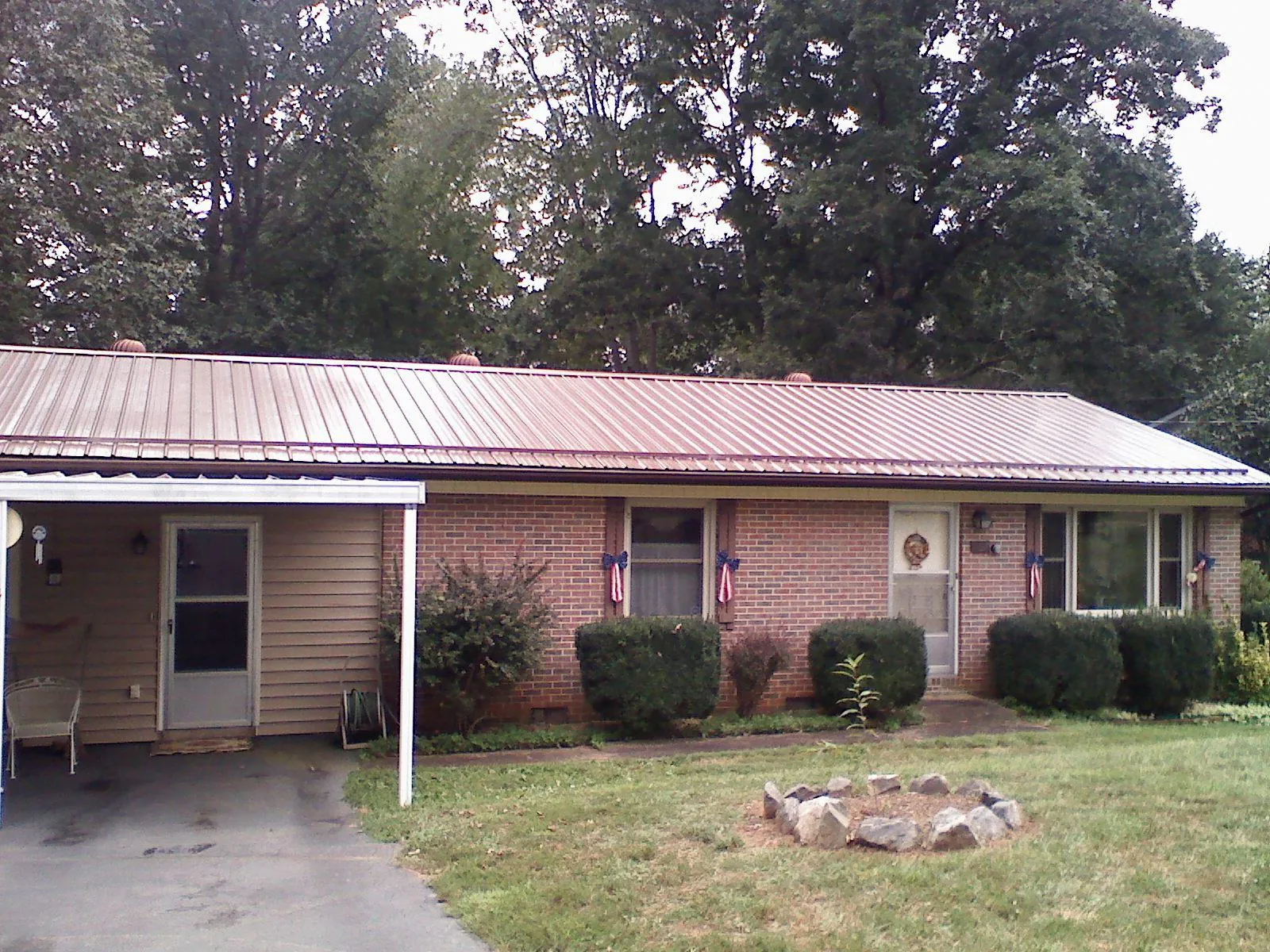Bronze metal roof and carport on a brick ranch home — Roof Repair work by our crew in Hagerman